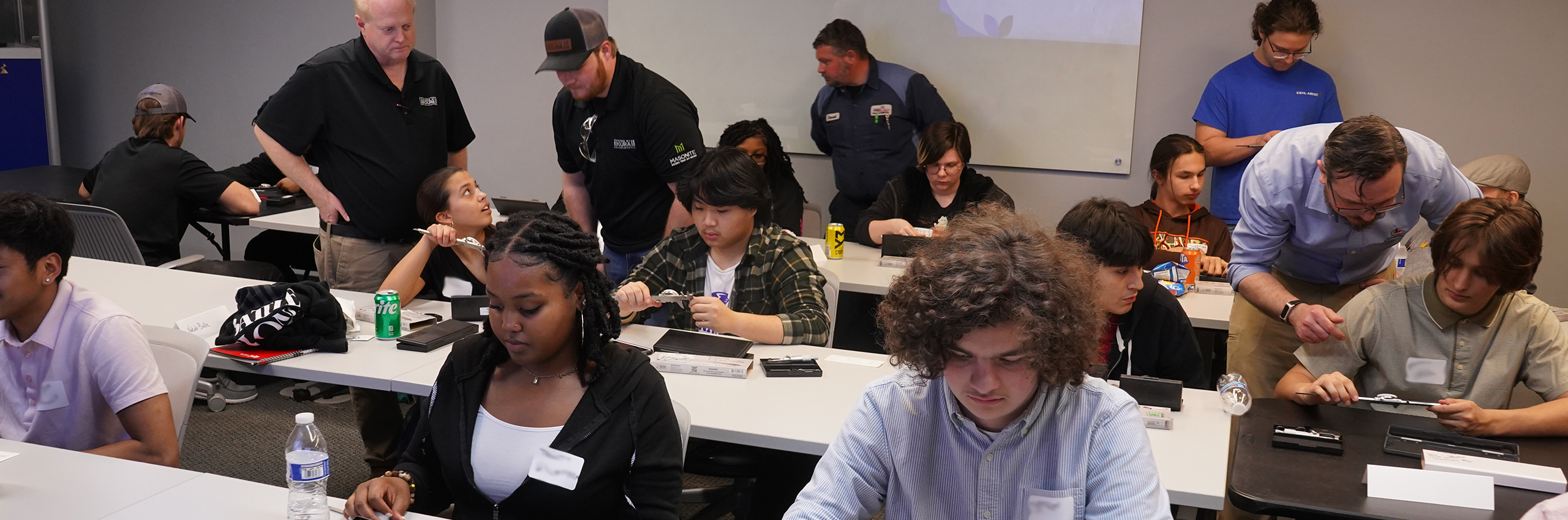 Apprentices in a learning room to whom a tool is explained